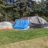Des tentes assemblées dans un parc. 