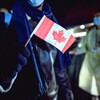 Un réfugié afghan tient un petit drapeau canadien à l'aéroport international de St. John's, le 26 octobre 2021.
