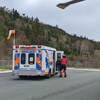 Une ambulance à côté d'un hélicoptère de recherche et sauvetage.