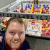Scott Templeton pose devant son arena en lego qui comporte des spectateurs et des joueurs.