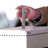 Un électeur dépose son bulletin de vote dans une boîte de scrutin. 