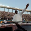 Le président sénégalais Macky Sall salue une foule de ses partisans à bord d'un véhicule.