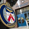 L'écusson de la police de Toronto en gros plan devant l'entrée de son quartier général.