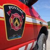 Une voiture rouge porte des lignes jaunes et blanche ainsi que les armoiries du Service de sécurité incendie de la Municipalité de Pontiac.