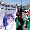 Une jeune manifestante avec une banderole demandant justice pour la journaliste tuée.