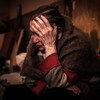 Une femme, Klaudia Pushnir, 88 ans, prend sa tête dans ses mains, en pleurant, dans un sous-sol. 