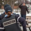 Dans une simulation, trois futurs policiers en formation s'apprêtent à intervenir auprès d'une personne qui boit dans un lieu public.