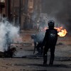 Des policiers surveillent une rue jonchée de débris.