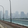 Montréal se dessine au loin dans un épais brouillard.