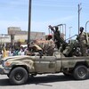 Au Soudan, un véhicule militaire avec des soldats armés qui sont salués par des citoyens. 
