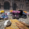 Des souliers d'enfants et d'autres objets déposés à Queen's Park à la mémoire des élèves morts au pensionnat pour Autochtones de Kamloops.