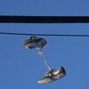 Des souliers sont suspendus à des fils électriques. 