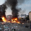 Une rue jonchée de détritus et des voitures incendiées dans une ville d'Angleterre. 