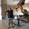 Le professeur de science et d'architecture Steven Beites avec un robot installé dans un atelier de l'École d'architecture McEwen.