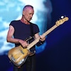 Sting joue de la basse sur scène. 