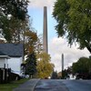 Une rue résidentielle de Sudbury une journée d'automne. En arrière-plan, la cheminée d'une fonderie de nickel.