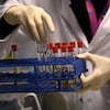 Un technicien manipule des échantillons d'urine.