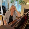 Suzanne Blais sourit, appuyée sur son piano.