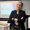 Sylvie Laurencelle-Vermette, les bras croisés, devant un écran projetant le nom de la Chambre de commerce de Saint-Boniface. 