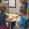 Des enfants s'amusent à une table.