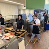 Des étudiants cuisinent dans une cuisine collective.