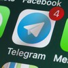 Une photo en gros plan d'un écran de téléphone sur lequel sont affichées les icônes de différentes applications de messagerie, dont celle de Telegram.