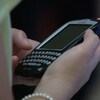 Téléphone BlackBerry avec clavier physique dans une main.