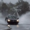 Une voiture roule dans une flaque d'eau durant une tempête.