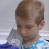 Un petit garçon fait un test de dépistage de la COVID à partir de la salive.