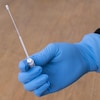 Une main qui présente un écouvillon utilisé pour les prélèvements du test de coronavirus. 