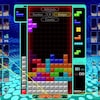 Une capture d'écran du jeu vidéo Tetris 99 montrant une pile de petits blocs colorés empilés les uns sur les autres sur une grille.