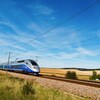 Un train à grande vitesse traverse un champ en France.