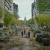 Trois personnes marchent dans une ville américaine post-apocalyptique. 