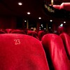 Des fauteuils rouges dans une salle de théâtre.