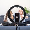 Deux jeunes ados filment une vidéo TikTok dans leur salon. 