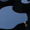 Tim Cook envoie la main sur une scène devant un immense logo d'Apple projeté sur un écran.