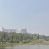 Un bâtiment se dessine sur une colline qui surplombe un lac. La vue est brouillée à cause de la fumée des feux de forêt le 5 juillet 2022.