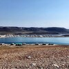 Maisons situées le long de la rive de l'océan Arctique, avec montagnes derrière, à Ulukhaktok, aux Territoires du Nord-Ouest.