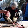 Une personne qui coupe un poisson avec un couteau, le 18 avril 2023, à Yellowknife.