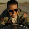 Tom Cruise est sur sa moto et il sourit.