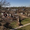 Vue aérienne de plusieurs maisons détruites et des arbres déracinés.
