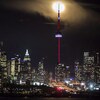 Le centre-ville de Toronto la nuit et la lune derrière la Tour CN. (Photo d'archives)