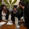 Deux femmes écoutent les conseils d'un vendeur dans un magasin de cannabis. 