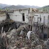 Un Afghan marche dans les décombres d'une maison détruite.