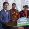 M. Trudeau, entouré des personnes mentionnées, livre un discours devant un lutrin.