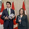 Justin Trudeau et Chrystia Freeland posent pour les journalistes avec le budget en main.