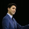 Justin Trudeau tient un micro tout en fixant des yeux.