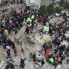 Des gens rassemblés près des décombres d'un édifice qui s'est effondré à la suite d'un tremblement de terre survenu en Turquie.