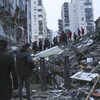 Des secouristes fouillent les décombres d'un immeuble effondré.