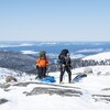Des participants de l'expédition Uapishka avec le paysage montagneux et le ciel en fond.